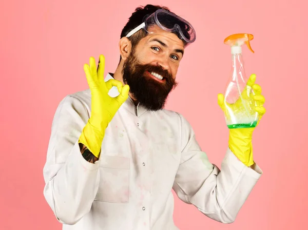 Glimlachende professionele reiniger in beschermende handschoenen met reinigingsspray teken ok. Huishouden en huishouden concept. — Stockfoto