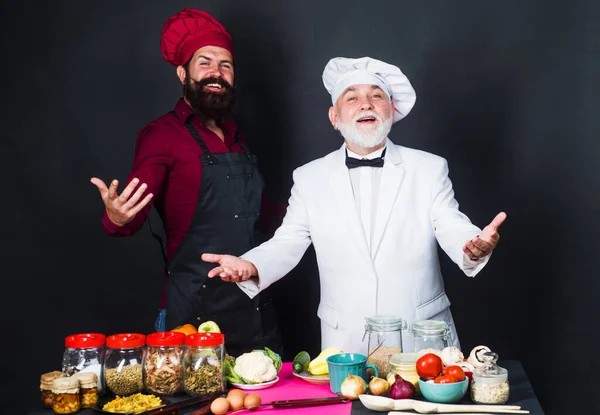 Batalha da cozinha. Dois chefs profissionais barbudos de uniforme. Tempo de cozedura. — Fotografia de Stock