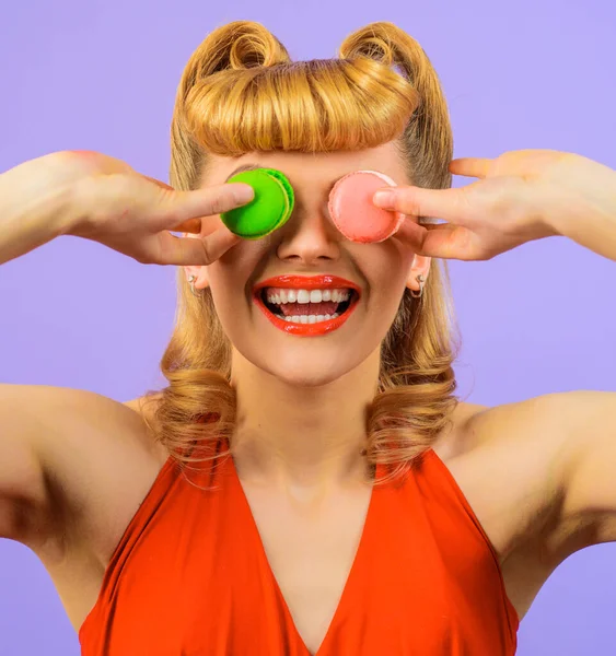 Fille souriante avec coiffure rétro avec des macarons. Desserts français. Bonbons, confiseries. — Photo