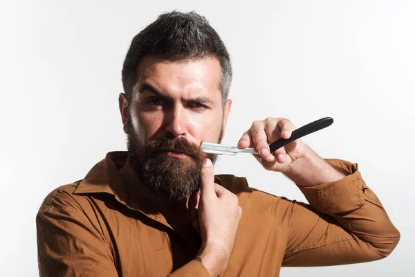 Een man met baard en scheermes. Stijlvolle kapper met kappersgereedschap in de kapperszaak. Kappersapparatuur. — Stockfoto