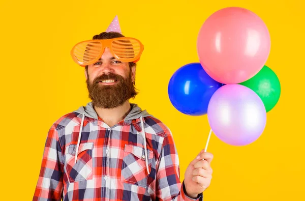 Feliz cumpleaños. Hora de la fiesta. Hombre barbudo con sombrero de fiesta y globos. Concepto de celebración, alegría, diversión y felicidad. — Foto de Stock