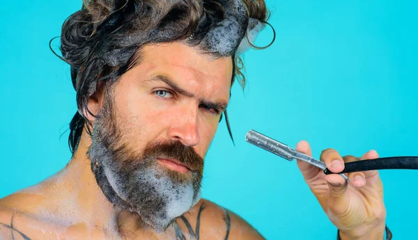 Bearded man shaving beard with straight razor in shower. Beard Care. Beauty, hygiene, grooming and people concept. — Stock Photo, Image