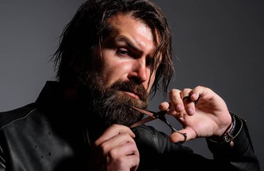 Sakalı makasla kesen yakışıklı adam. Berber dükkanı reklamı. Erkekler için salon.