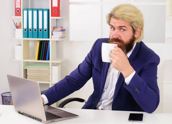 Επιχειρηματίας στο γραφείο που εργάζεται με φορητό υπολογιστή και πίνει καφέ. Επιχειρηματίας με κοστούμι. Απολαμβάνοντας φρέσκο καφέ στη δουλειά. — Φωτογραφία Αρχείου