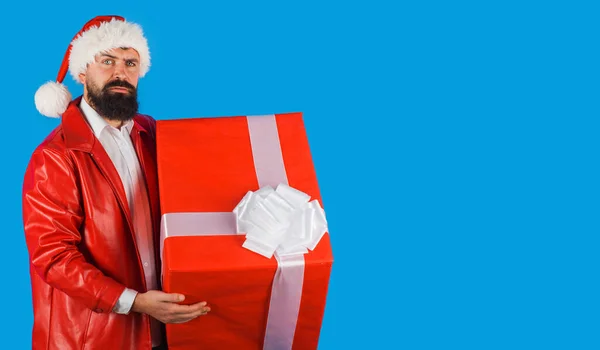 圣诞老人与礼物。圣诞节的时候戴著礼品盒头戴圣诞礼帽的男人.新年广告。复制空间. — 图库照片