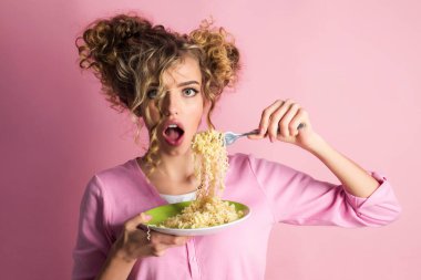 Lezzetli İtalyan spagettisi yiyen güzel bir kadın. Elinde hazır şehriye tabağı olan seksi kız. Fast food teslimatı. Sabah kahvaltısı. Kıvırcık saçlı moda kadın lezzetli makarna yiyor.