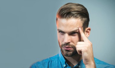 Düşünen adam. Kot gömlekli düşünceli adam bir şey düşünüyor. Sıradan giyinen, geleceği düşünen, yeni bir başlangıç planlayan ciddi bir adam. Güzel saç stili olan yakışıklı adam başka tarafa bakıyor.