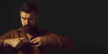 Berber dükkanındaki adam. Berberde keskin bir jilet var. Berber dükkanı. Berber dükkanında ustura kullanan yakışıklı bir kuaför. Düz tıraş bıçağı, berber dükkanı. Reklam afişi. Boşluğu kopyala