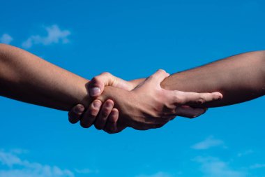 Gökyüzü arka planına yardım ediyorum. Yardım eli uzatıyorum. Kurtarma, el hareketlerine yardım et. El konseptine ve desteğe yardımcı oluyor. Silah kurtuluşu. Bir dosta yardım eden iki el, takım çalışması.