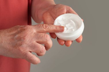 Yaşlanmış eller kırışıklıklar gösterir. Kremalı yaşlı cilt. Yaşlanmış cilt bakımı. Yaşlanmış deri dokusu. Kremalı yaşlı kadın elleri. Son sınıf el kremi.