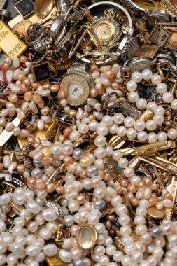 Antika mücevherler altın bir arka planda sıkıca paketlenmiştir. Mücevher değerli ve eski görünüyor. Altın metal antika arka planı destekler. Bu mücevher geçmişinin değeri