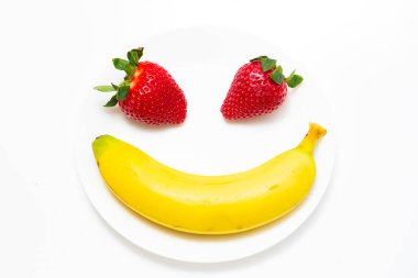 Yaz tatlı meyve muzları ve çilekler. Muz ve çilek arka planı. Taze olgun muzlar ve kırmızı çilekler. Muz dilimleri ve çilekler