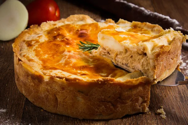Brazilian Chicken Pie - Slice of a Homemade Chicken Pie on Spatula on a Wooden Table Rustic Appeal
