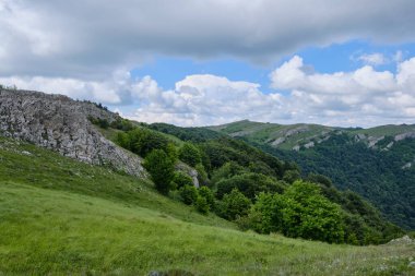 Kırım dağlarının açık yeşil yamaçlarında bulutlu yaz havasında. Demerdzhi dağ sırası, Kırım.