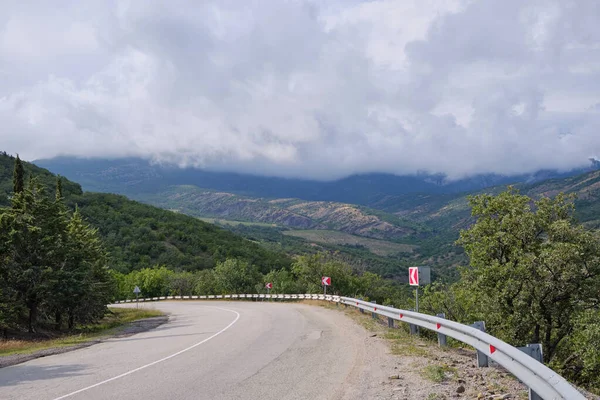 Primorsky Serpentine yolu Sudak 'a doğru Demerdzhi dağ sırasının arka planına karşı. Kırım.