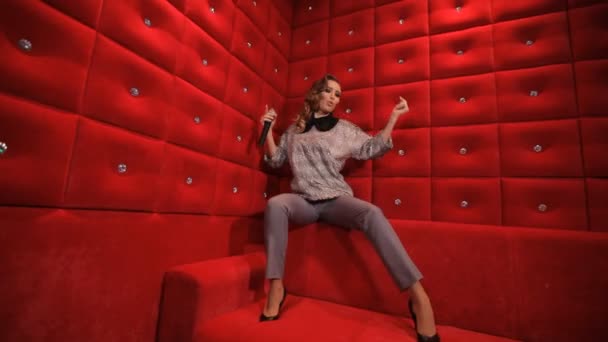 Schönes Mädchen singt auf rotem Hintergrund — Stockvideo
