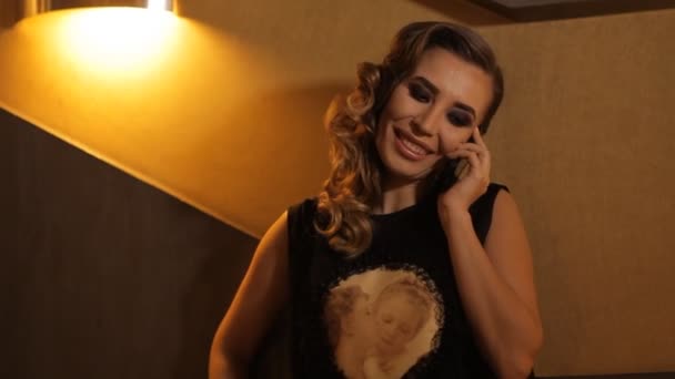 Mooi meisje in een restaurant praten aan de telefoon — Stockvideo