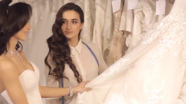 The Consultant Helps The Girl To Choose A Wedding Dress Stock