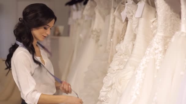 Huwelijk Salon probleemoplosser helpt het meisje om te kiezen van de jurk — Stockvideo