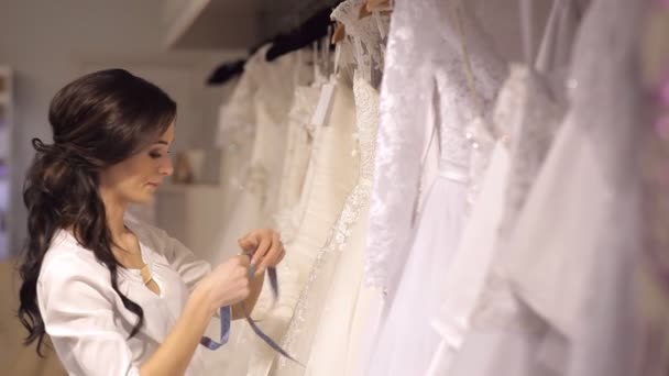 Asesora de salón de bodas ayuda a la chica a elegir el vestido — Vídeos de Stock