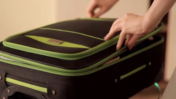 The girl collects things in a suitcase for vacation — Stock Video