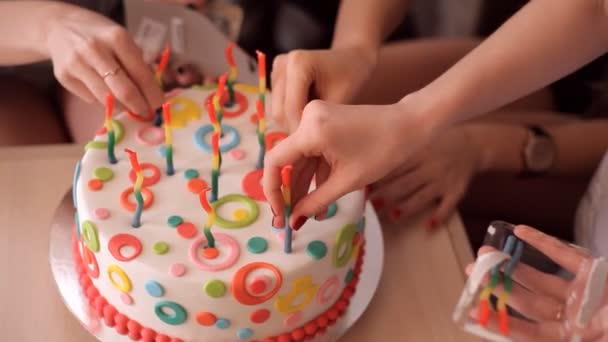 Las niñas insertan velas en el pastel — Vídeo de stock