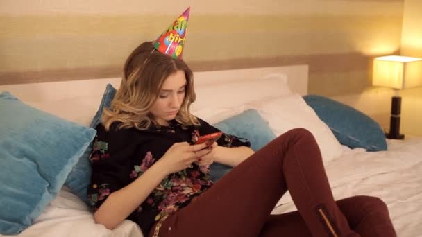 Молода дівчина лежить і використовує мобільний телефон — стокове відео