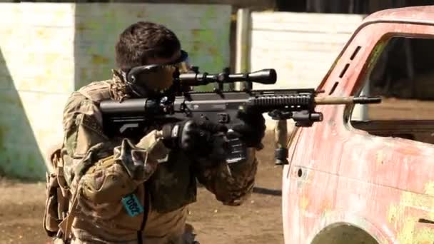 Paintball jogador em uniforme protetor e máscara apontando arma antes de atirar — Vídeo de Stock