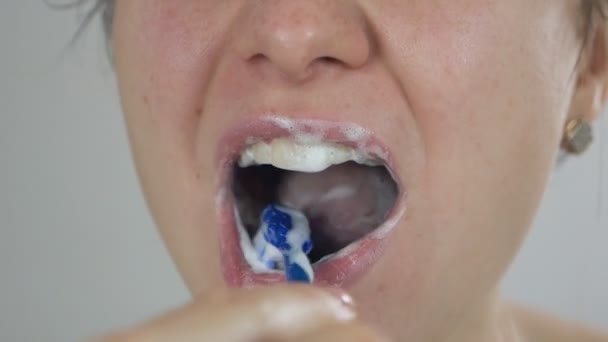 Крупним планом жінка чистить зуби зубною щіткою і зубною пастою, роблячи гігієну порожнини рота вдома. Стиль життя, здорові люди та концепція догляду за зубами — стокове відео