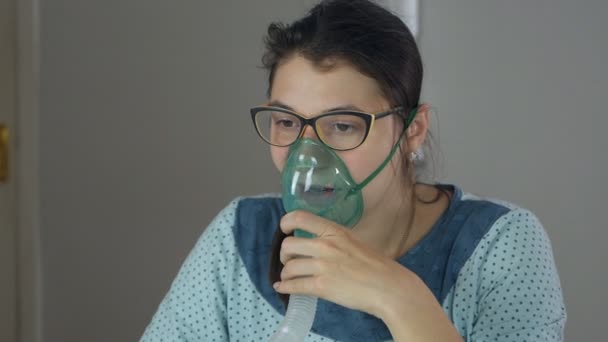 Jeune femme malade à la maison avec un mal de gorge fait inhalation avec un masque sur son visage. Le patient est traité avec un nébuliseur. Prévention de l'infection à coronavirus — Video