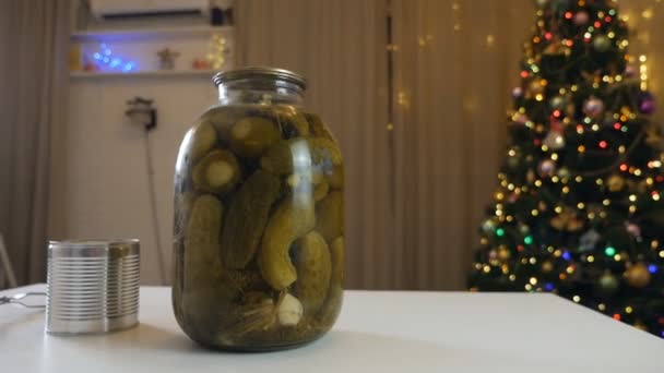 Pot en verre avec des concombres marinés maison sur le fond de l'arbre de Noël et un pot avec un pot vert, pour faire une salade traditionnelle, Olivier — Video