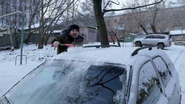 Limpiando el coche de la nieve. clima invernal — Vídeo de stock