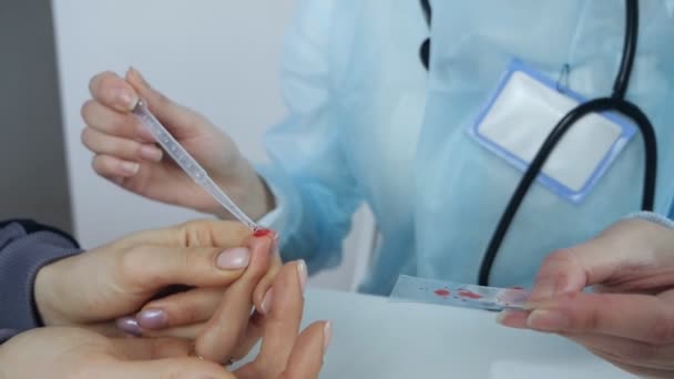 Esame del sangue a punta delle dita. Un medico preleva un campione di sangue da un dito di paziente per testare il COVID-19 — Video Stock