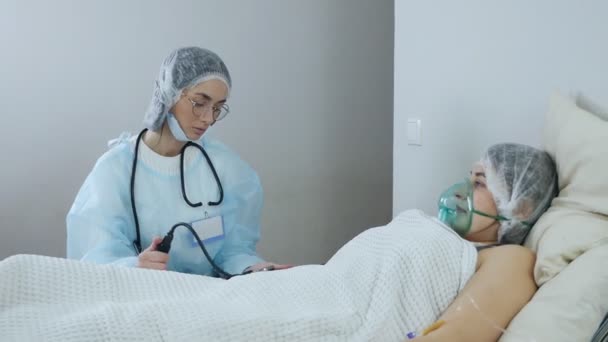 Um médico profissional senta-se em um quarto de hospital e mede a pressão arterial do paciente. Conceito de cuidados de saúde e prevenção — Vídeo de Stock