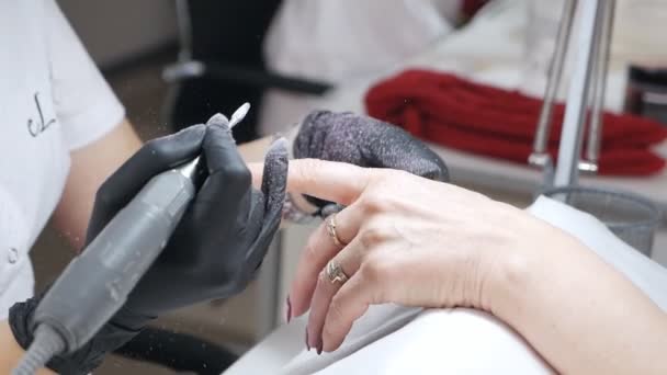 Um mestre de manicura e pedicuro retira o polonês de gel de um prego. close-up de manicure. extensão do prego. um mestre de manicure trabalha com um cortador. Remoção de material — Vídeo de Stock