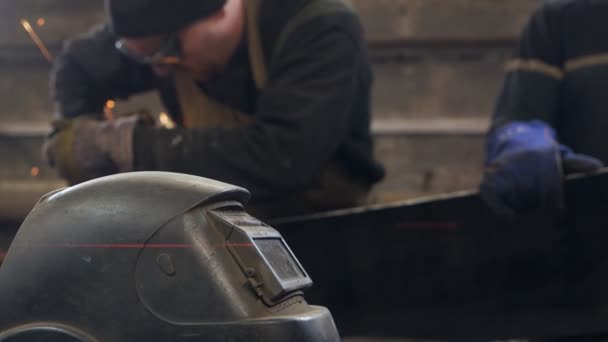 Man in beschermende kleding tijdens het werken in de metaalsnijwerkplaats op de achtergrond. Fabriek. snijden van metaal — Stockvideo