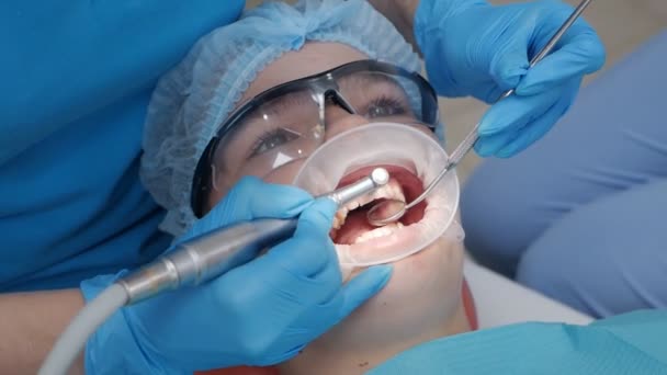 Dentysta z pielęgniarką i pacjentem w gabinecie dentystycznym. Pacjent leczony stomatologicznie w gabinecie stomatologicznym, dentysta i asystent podczas pracy zespołowej — Wideo stockowe