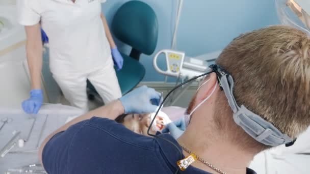 在现代的牙科诊所里，牙医与病人一起工作。慢动作 — 图库视频影像