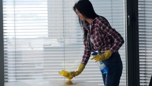 Mujer joven usando spray de limpieza en una superficie de madera. Limpieza — Vídeos de Stock