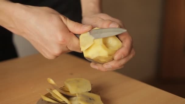 Homme a coupé des pommes de terre dans la cuisine — Video