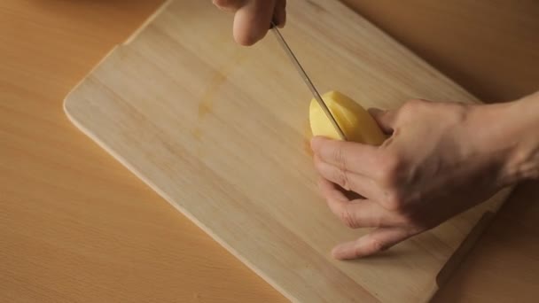 Člověk nakrájíme brambory v kuchyni — Stock video