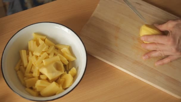 Man skär potatis i köket — Stockvideo