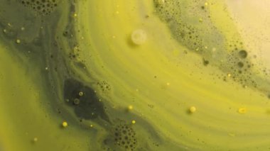 Gri ve sarı akrilik boya baloncukları hareket eder ve sütte patlar