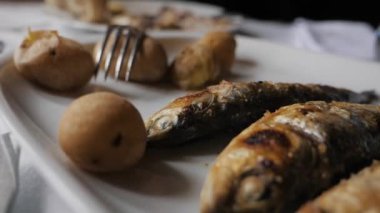 Sardalya ateşte kızardı. Kamera hareket ediyor