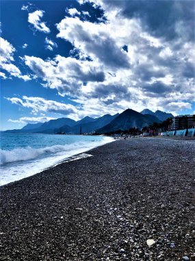 Türkiye deniz ufku mavi gökyüzü ağaçları Antalya dağlarında geziniyor çakıl taşları kumsalda