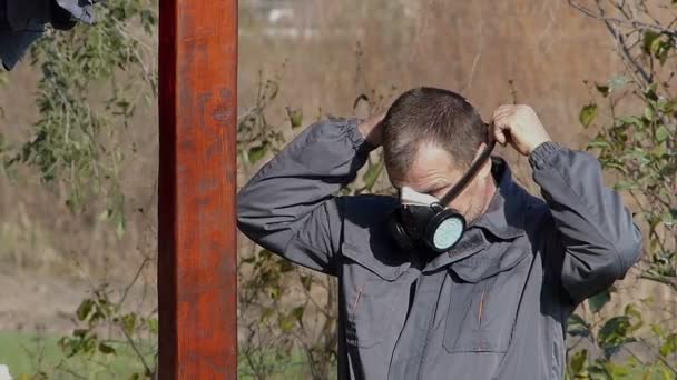 Tuinman beschermende uitrusting voor het spuiten van plant te zetten. — Stockvideo