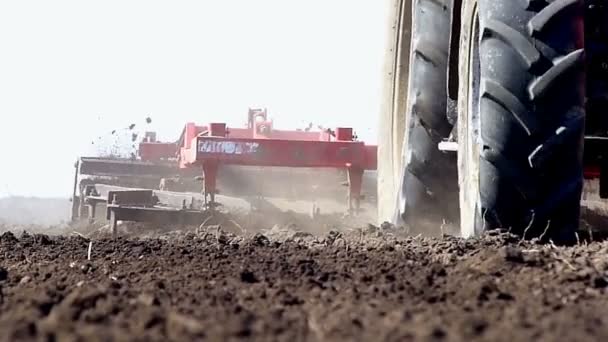 Traktor zieht Ackerbaumaschine — Stockvideo