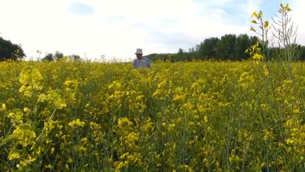 Fermier âgé dans un champ de colza 
