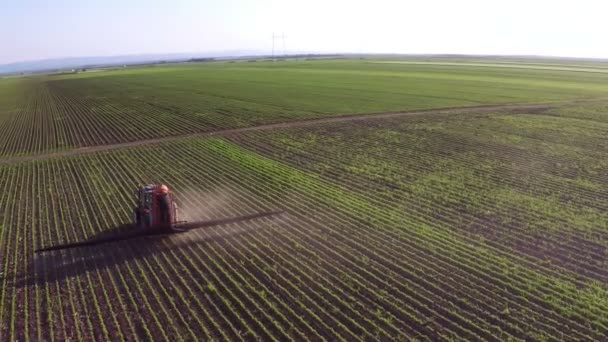 Tracteur saupoudre le champ de soja avec des produits chimiques 