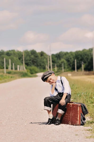 Jeune voyageur fatigué assis sur la route — Photo